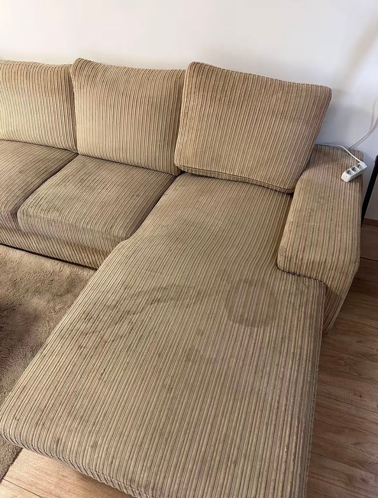 Beige ribbed fabric sectional sofa with chaise lounge in living room with hardwood floor